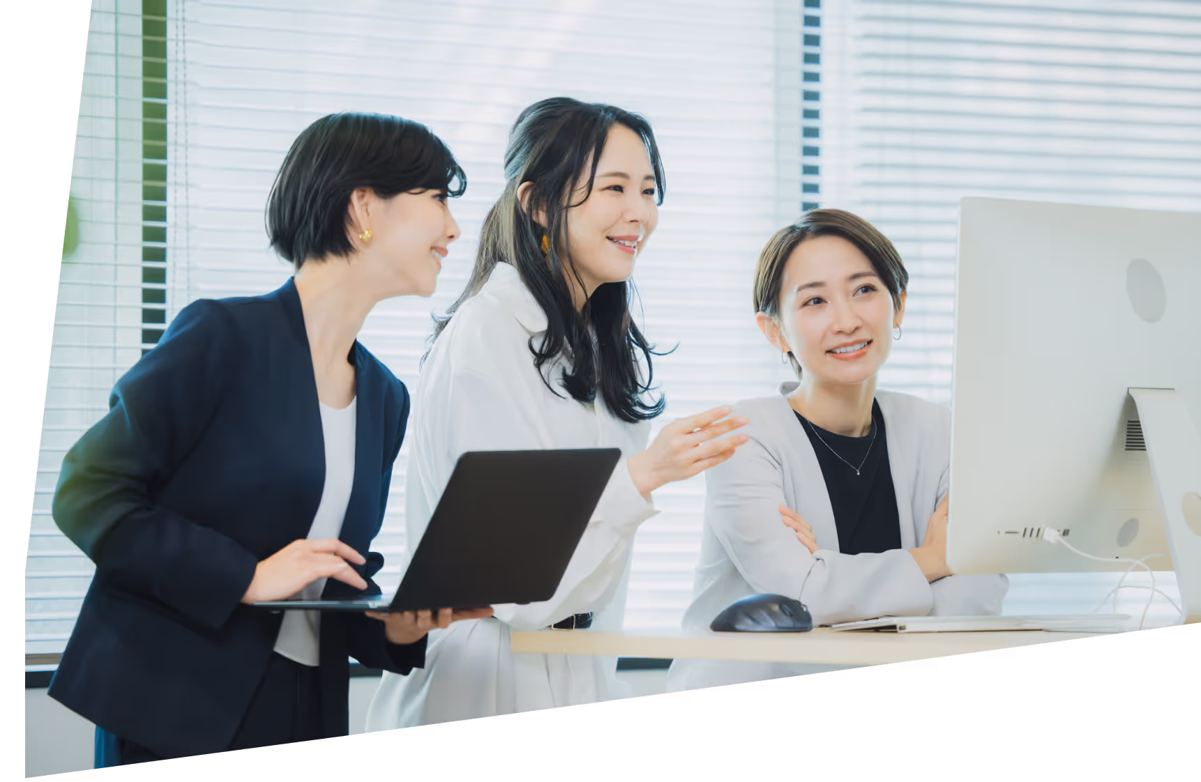 3人の女性がPCを見て話し合いをしている様子