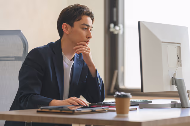 何かを考えながら作業をする男性の様子