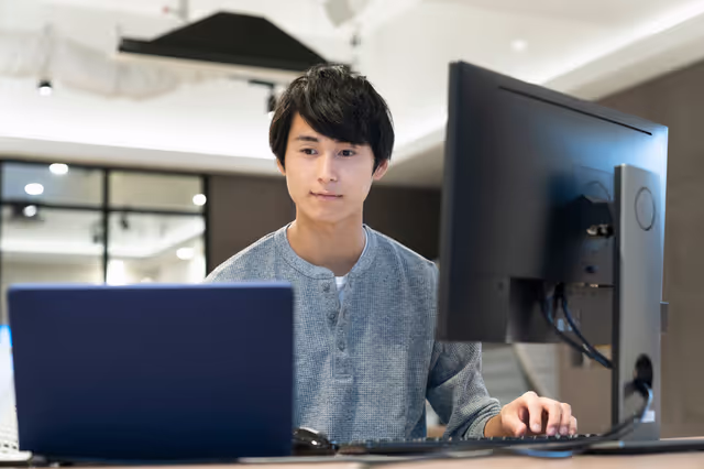 複数の画面で作業をする社員の様子