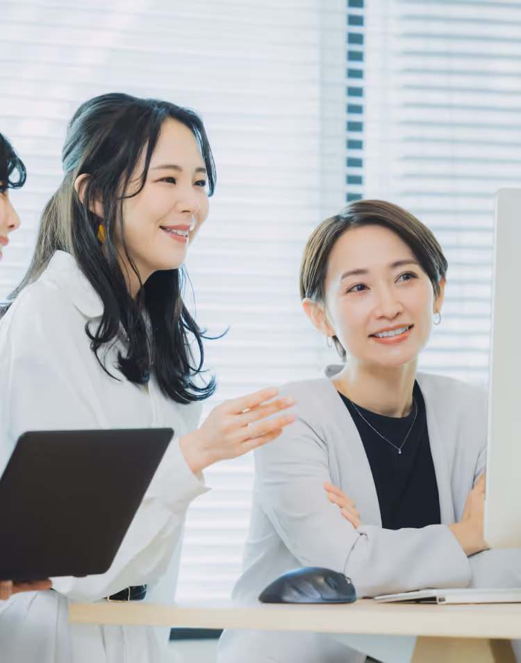 3人の女性がPCを見て話し合いをしている様子